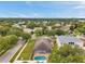 Aerial view showcasing a backyard with a screened pool, green lawn and mature trees in a quiet residential neighborhood at 1328 Rushgrove Cir, Dover, FL 33527
