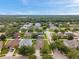 This image displays an expansive yard with lush green trees, sidewalks and other houses in a quiet neighborhood at 1328 Rushgrove Cir, Dover, FL 33527