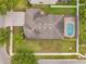 An overhead view showcasing the roof, driveway, yard with pool and lush landscaping, plus a sidewalk in a quiet neighborhood at 1328 Rushgrove Cir, Dover, FL 33527