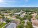 An elevated shot of green lawns and mature trees in a Gathering friendly neighborhood with houses lining the streets at 1328 Rushgrove Cir, Dover, FL 33527