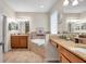 Spacious bathroom featuring dual sinks, a vanity, a soaking tub, and neutral tile at 1328 Rushgrove Cir, Dover, FL 33527