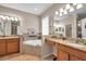 Spacious bathroom featuring dual sinks, a vanity, a soaking tub, and neutral tile at 1328 Rushgrove Cir, Dover, FL 33527