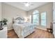 Calm bedroom featuring a floral comforter, hardwood floors, and a large window with arched accent at 1328 Rushgrove Cir, Dover, FL 33527