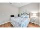 This cozy bedroom has a wrought iron bedframe, hardwood floors, and a small TV and is move-in ready at 1328 Rushgrove Cir, Dover, FL 33527