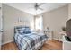 This comfy bedroom boasts light hardwood floors, a ceiling fan, and a decorative blue plaid comforter set at 1328 Rushgrove Cir, Dover, FL 33527