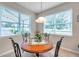 Bright breakfast nook with a wood table, decorative centerpiece, and large windows for natural light at 1328 Rushgrove Cir, Dover, FL 33527