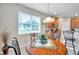 Eat-in kitchen features a wood table next to bright windows, adjacent to modern appliances and the kitchen at 1328 Rushgrove Cir, Dover, FL 33527