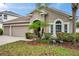A lovely yard features lush landscaping and decorative crane ornaments at 1328 Rushgrove Cir, Dover, FL 33527