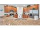 Bright kitchen featuring granite countertops, wood cabinetry, and stainless steel appliances at 1328 Rushgrove Cir, Dover, FL 33527