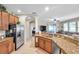 Open kitchen with granite countertops and stainless steel appliances and view to living room at 1328 Rushgrove Cir, Dover, FL 33527