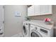 This well-equipped laundry room has overhead storage and countertop space for sorting and folding at 1328 Rushgrove Cir, Dover, FL 33527