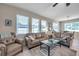 Inviting living room features neutral tones, plush seating, and ample natural light from the large windows at 1328 Rushgrove Cir, Dover, FL 33527