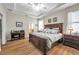 Spacious main bedroom with a tray ceiling, wood floors, and a decorative furniture set at 1328 Rushgrove Cir, Dover, FL 33527