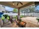 Inviting screened patio featuring wicker furniture, ceiling fan, and an outdoor view, perfect for relaxation at 1328 Rushgrove Cir, Dover, FL 33527