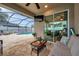Relaxing screened patio with pool access, cozy seating, ceiling fan, and outdoor television for entertainment at 1328 Rushgrove Cir, Dover, FL 33527