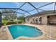 Screened in backyard pool with brick pavers and steps leading into the pool at 1328 Rushgrove Cir, Dover, FL 33527
