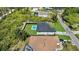 Overhead shot of the property displaying the pool and black fence, surrounded by trees and neighboring homes at 14009 Wenzel Ave, Port Charlotte, FL 33981