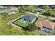 Aerial view of house and yard with pool surrounded by black fence in neighborhood at 14009 Wenzel Ave, Port Charlotte, FL 33981