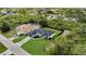 Beautiful aerial view of the house, showcasing its dark roof, green lawn, and proximity to lush greenery at 14009 Wenzel Ave, Port Charlotte, FL 33981