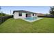Backyard featuring a private pool, well-maintained lawn, and modern home exterior at 14009 Wenzel Ave, Port Charlotte, FL 33981