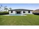 Spacious backyard featuring a refreshing pool, manicured lawn, and modern home at 14009 Wenzel Ave, Port Charlotte, FL 33981