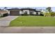 Contemporary home with a paved driveway, lush lawn, and well-manicured landscaping enhancing its curb appeal at 14009 Wenzel Ave, Port Charlotte, FL 33981