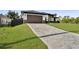 Beautiful home exterior with a paver driveway, manicured lawn, and a two-car garage at 14009 Wenzel Ave, Port Charlotte, FL 33981