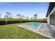 Serene backyard with a modern pool, verdant lawn, and mature trees at 14009 Wenzel Ave, Port Charlotte, FL 33981