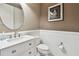 Elegant half bathroom with stylish fixtures, vanity, toilet and white wainscoting at 14110 Barrington Stowers Dr, Lithia, FL 33547