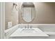 Well-lit half bathroom with vanity, round mirror, wainscoting and modern fixtures at 14110 Barrington Stowers Dr, Lithia, FL 33547