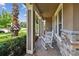Cozy front porch with classic rocking chair, stone accents, and well-maintained landscaping for relaxed outdoor living at 14110 Barrington Stowers Dr, Lithia, FL 33547