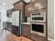 Kitchen boasts stainless steel appliances, dark wood cabinets, and quartz countertops at 14110 Barrington Stowers Dr, Lithia, FL 33547