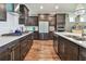 Modern kitchen featuring stainless steel appliances, dark wood cabinets, and quartz countertops at 14110 Barrington Stowers Dr, Lithia, FL 33547