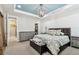 Bright main bedroom featuring tray ceilings, stylish chandelier and a dresser in the background at 14110 Barrington Stowers Dr, Lithia, FL 33547