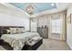 Spacious main bedroom with a patterned bedspread, tray ceiling, chandelier and two windows at 14110 Barrington Stowers Dr, Lithia, FL 33547