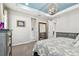 Bright main bedroom featuring tray ceilings, stylish chandelier and a dresser in the background at 14110 Barrington Stowers Dr, Lithia, FL 33547