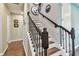Staircase with wooden steps, iron balusters, and decorative wall art at 14110 Barrington Stowers Dr, Lithia, FL 33547