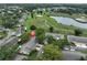 Aerial view of community, showcasing well-maintained homes, lush greenery, and serene pond at 1508 Ingram Dr # 20, Sun City Center, FL 33573