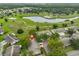 Community aerial view, highlighting homes, mature trees, and tranquil pond at 1508 Ingram Dr # 20, Sun City Center, FL 33573