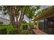 Charming backyard view showcasing mature trees, a well-manicured lawn, and sliding glass doors at 1508 Ingram Dr # 20, Sun City Center, FL 33573