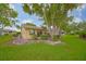 Picturesque backyard featuring mature trees, a well-manicured lawn, and a charming patio area at 1508 Ingram Dr # 20, Sun City Center, FL 33573
