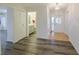 Bright hallway featuring hardwood floors, white doors, and access to bathroom at 1508 Ingram Dr # 20, Sun City Center, FL 33573
