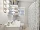 Cozy bathroom with floral shower curtain, vanity lighting, and floating shelves at 1525 38Th N Ave, St Petersburg, FL 33704