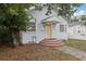 Home exterior with a yellow front door and brick paver steps with a large tree in the yard at 1525 38Th N Ave, St Petersburg, FL 33704