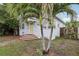 Home exterior with a yellow front door and brick paver steps, framed by palm trees and greenery at 1525 38Th N Ave, St Petersburg, FL 33704