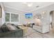 Cozy living room with sectional sofa, whitewashed floors, and a large window for natural light at 1525 38Th N Ave, St Petersburg, FL 33704