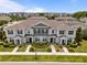 Aerial view showcasing the front of the townhome units with neat landscaping and exterior details at 15430 Caravan Ave, Odessa, FL 33556