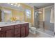 Bright bathroom with double sinks, quartz countertops, and a walk-in shower with glass doors at 15430 Caravan Ave, Odessa, FL 33556