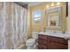 Bathroom boasts a vanity, framed mirror, framed window, and shower with patterned curtain at 15430 Caravan Ave, Odessa, FL 33556