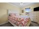 Bright bedroom features a large window, ceiling fan, and a comfortable bed with colorful patterned bedding at 15430 Caravan Ave, Odessa, FL 33556
